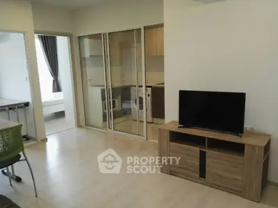 Modern apartment interior with open living room and kitchen, featuring wooden flooring and sleek furniture.