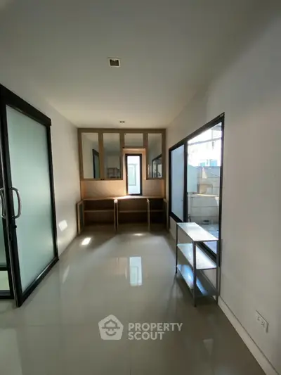 Modern interior space with glass doors and sleek shelving unit
