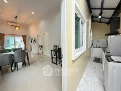 Modern open-plan living and dining area with adjacent kitchen in a stylish home.