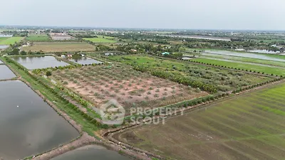 Expansive agricultural land with lush greenery and water bodies, ideal for farming or development.