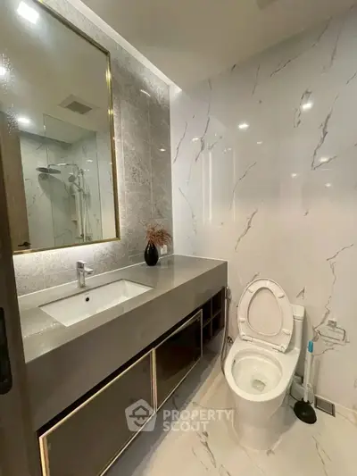 Luxurious modern bathroom with elegant marble tiles and sleek vanity design.