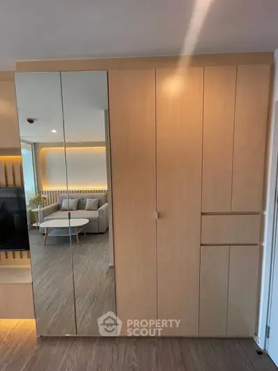 Modern living room with sleek wooden cabinetry and mirrored doors