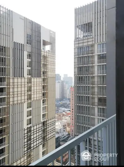 Stunning urban view from a high-rise balcony overlooking modern cityscape.