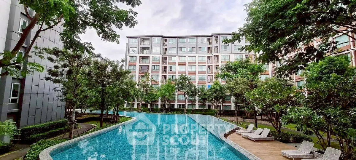 Luxurious apartment complex with stunning pool and lush greenery, perfect for modern living.
