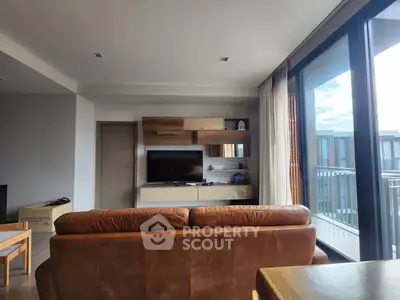 Modern living room with leather sofa and balcony view in a stylish apartment.