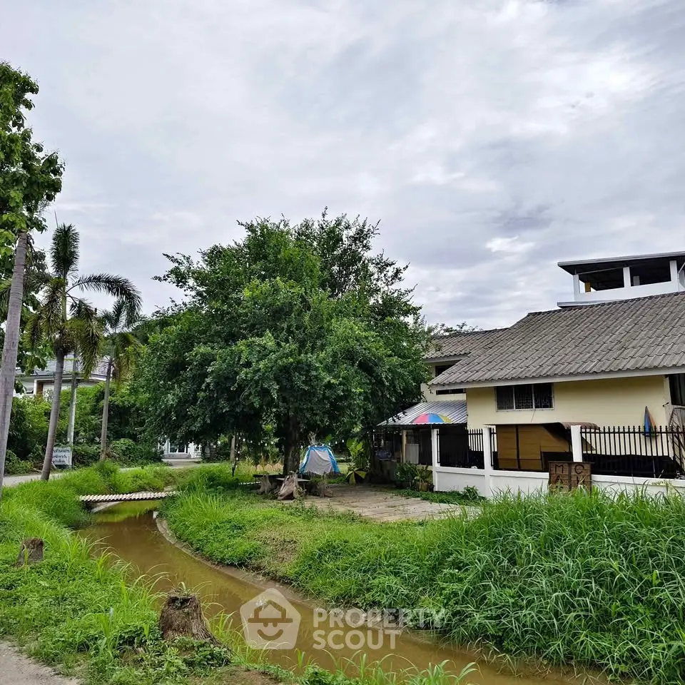 Charming suburban house with lush greenery and a serene canal view, perfect for nature lovers seeking tranquility.