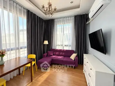 Stylish living room with purple sofa, chandelier, and modern decor