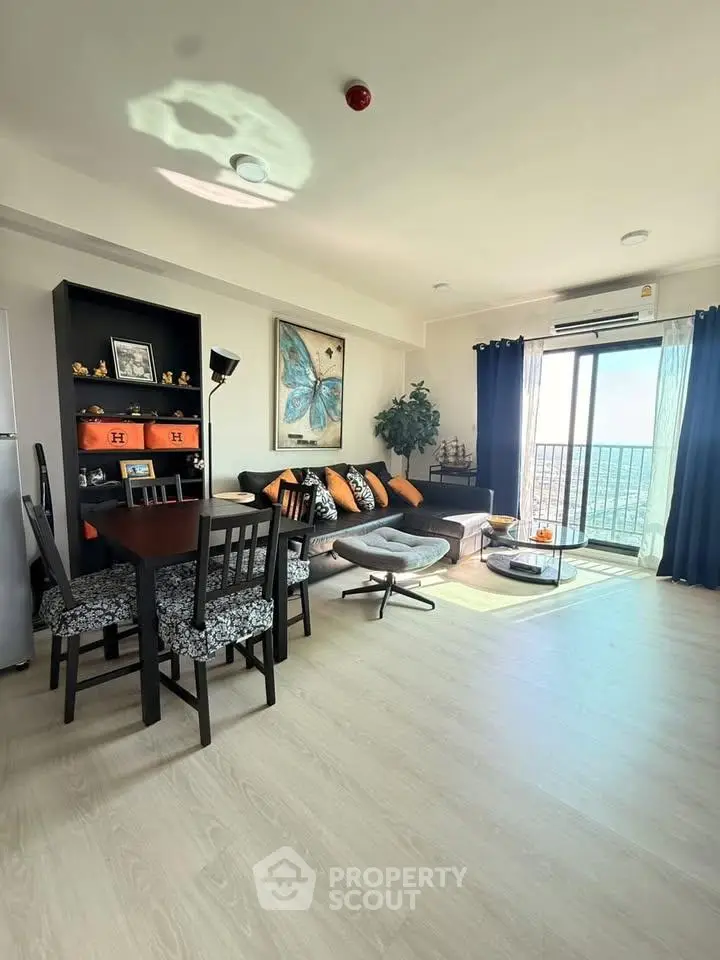 Spacious living room with modern decor and balcony view in a high-rise apartment.