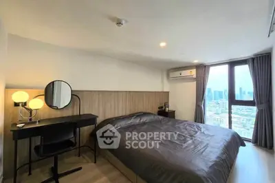 Modern bedroom with city view, featuring a cozy bed, stylish desk, and large window for natural light.