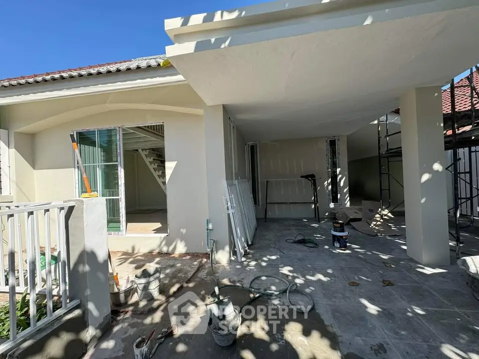 Charming house exterior under renovation with spacious patio and modern design elements.