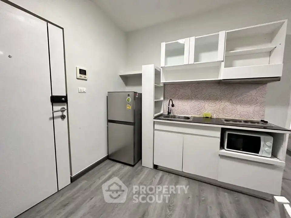 Modern compact kitchen with sleek appliances and minimalist design