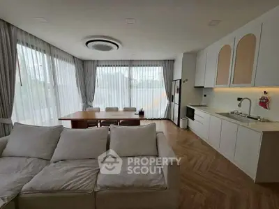 Spacious modern living room with large windows and elegant dining area