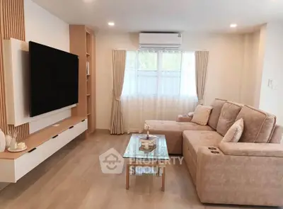 Modern living room with large TV, cozy sectional sofa, and elegant decor