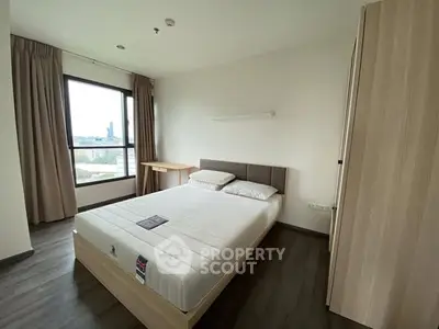 Modern bedroom with large window and city view, featuring a comfortable bed and sleek wooden furniture.