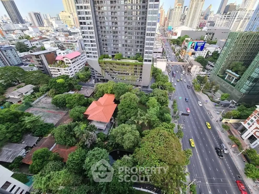 Stunning aerial view of urban high-rise buildings and lush greenery in a vibrant cityscape.