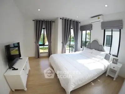 Bright and airy bedroom with modern decor and large windows offering scenic views.
