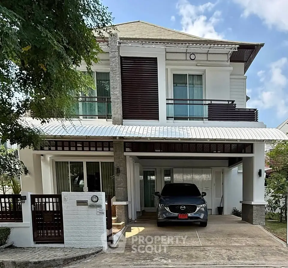 Stunning two-story modern house with carport and lush greenery, perfect for family living.
