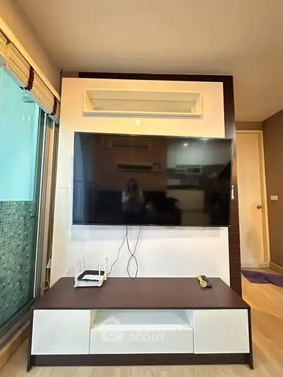 Modern living room with wall-mounted TV and stylish furniture