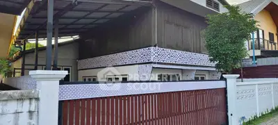 Charming two-story house with decorative exterior panels and a spacious covered carport.