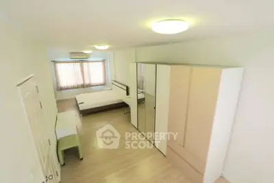 Spacious bedroom with modern furnishings and ample natural light, perfect for comfortable living.