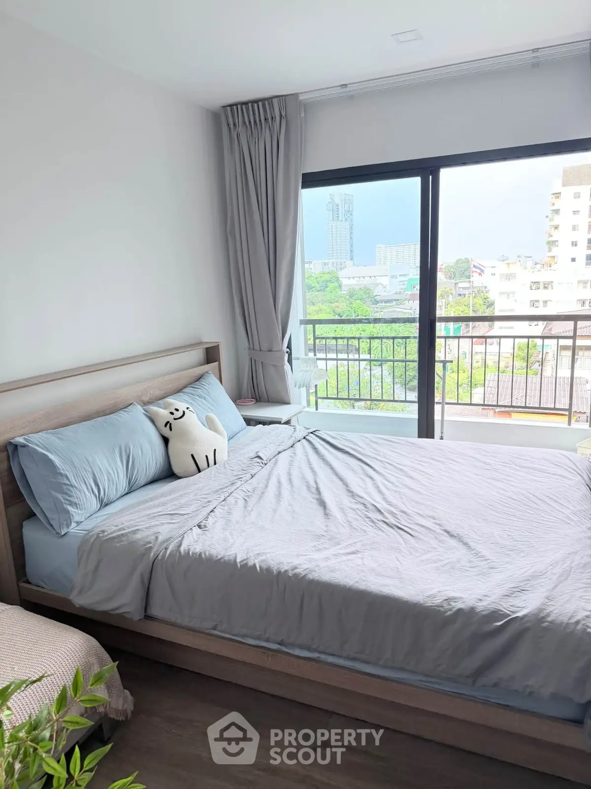 Bright bedroom with large window and balcony view in modern apartment