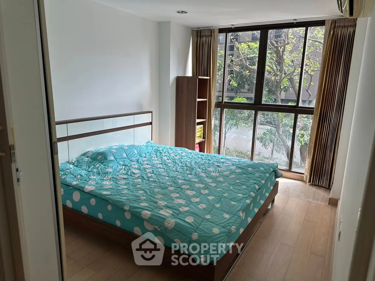 Bright bedroom with large window and modern decor in urban apartment