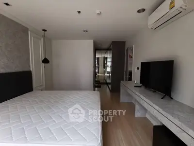 Modern bedroom with minimalist design and wall-mounted TV