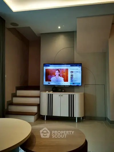 Modern living room with wall-mounted TV and stylish furniture