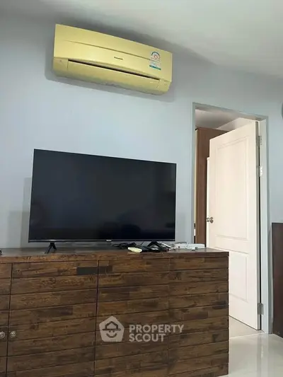 Modern living room with sleek TV and air conditioning unit, perfect for comfortable living.