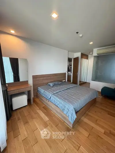 Spacious bedroom with modern wooden flooring and stylish decor