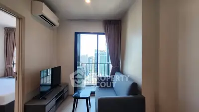 Modern living room with city view, featuring sleek furniture and large windows for natural light.