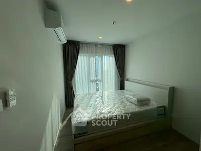 Modern bedroom with large window and natural light in a stylish apartment.
