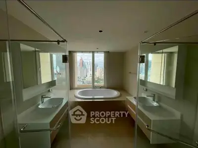 Luxurious bathroom with city view, featuring dual sinks and a central bathtub.