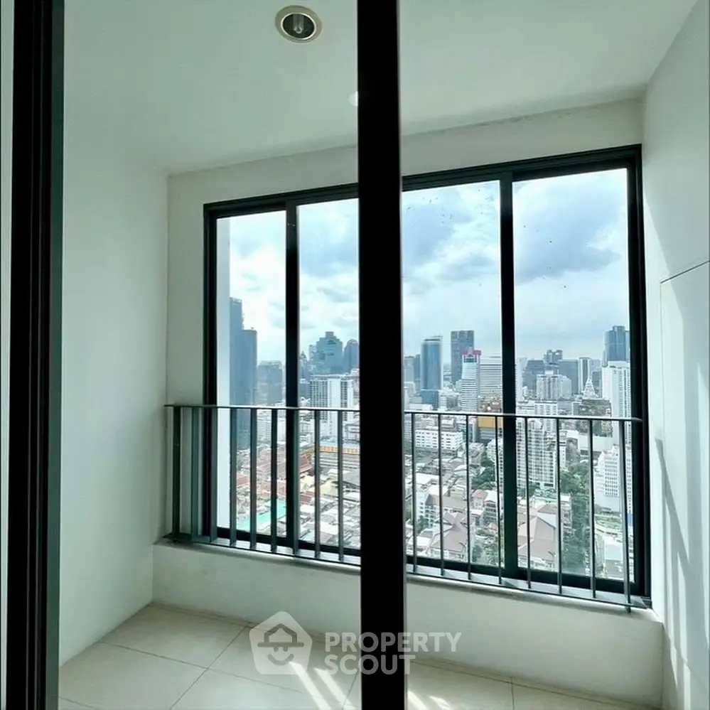 Stunning city view from modern high-rise balcony with floor-to-ceiling windows.