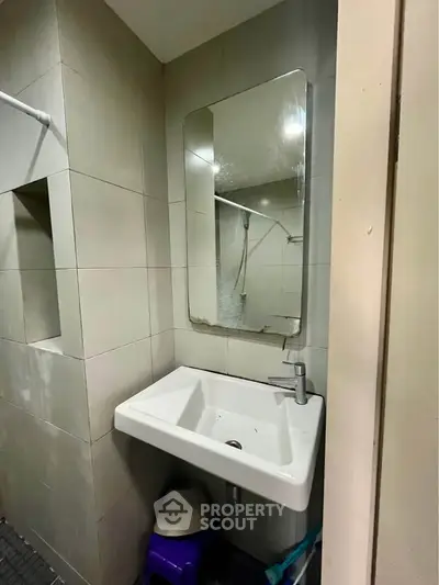 Compact bathroom with modern sink and mirror, ideal for efficient space use.