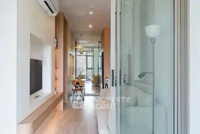 Modern open-plan living room with sleek design and natural light, featuring a cozy seating area and dining space.