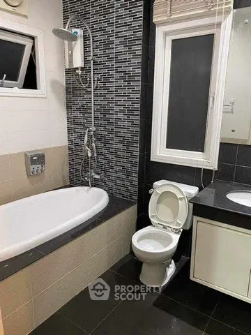 Modern bathroom with bathtub and sleek black tile design