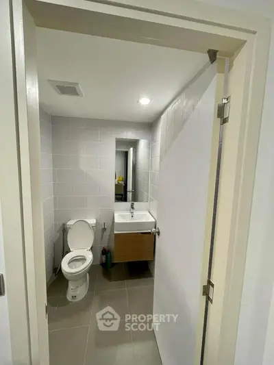 Modern compact bathroom with sleek fixtures and neutral tiles