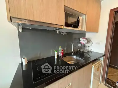 Modern compact kitchen with sleek cabinetry and built-in appliances in a stylish apartment.