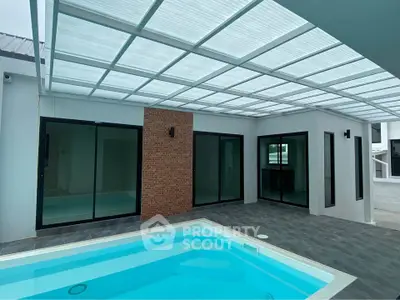 Modern home with sleek pool and glass doors under a stylish pergola.