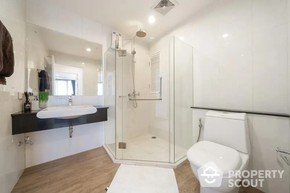 Modern bathroom with glass shower, sleek fixtures, and elegant design.