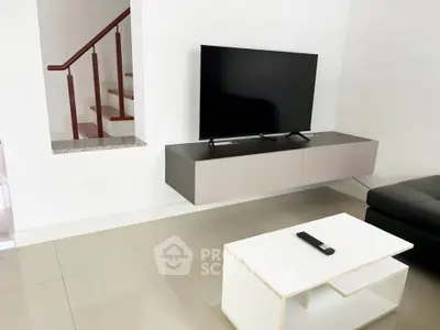 Modern living room with sleek TV setup and minimalist coffee table, perfect for contemporary living.
