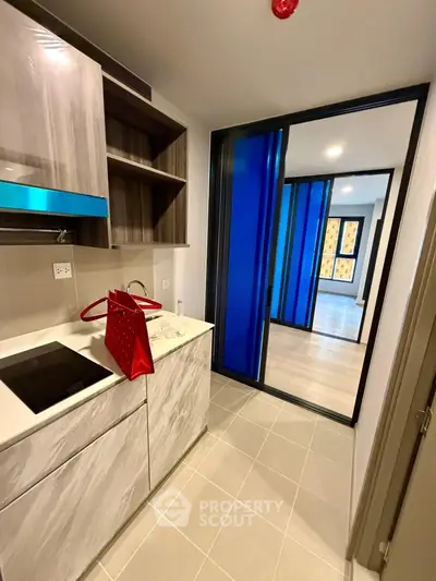 Modern kitchen with sleek cabinetry and electric cooktop in stylish apartment