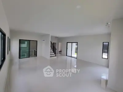 Spacious modern living room with large windows and sleek tile flooring