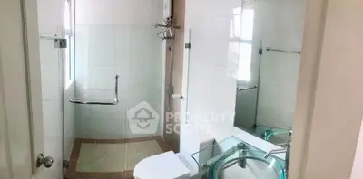Modern bathroom with glass sink and walk-in shower