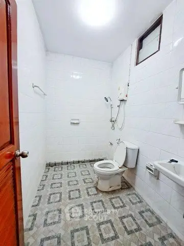 Spacious bathroom with modern fixtures and patterned tile flooring.