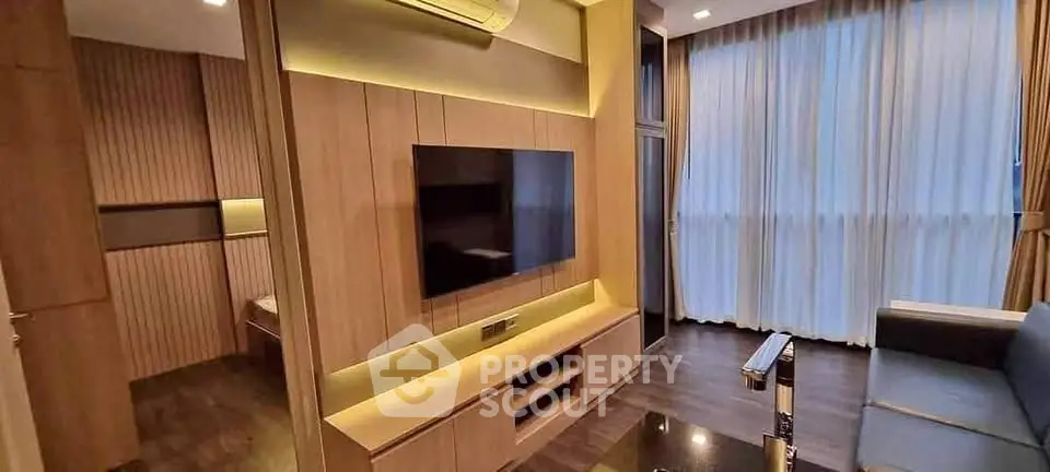 Modern living room with sleek wooden paneling and large TV, featuring ambient lighting and floor-to-ceiling windows.
