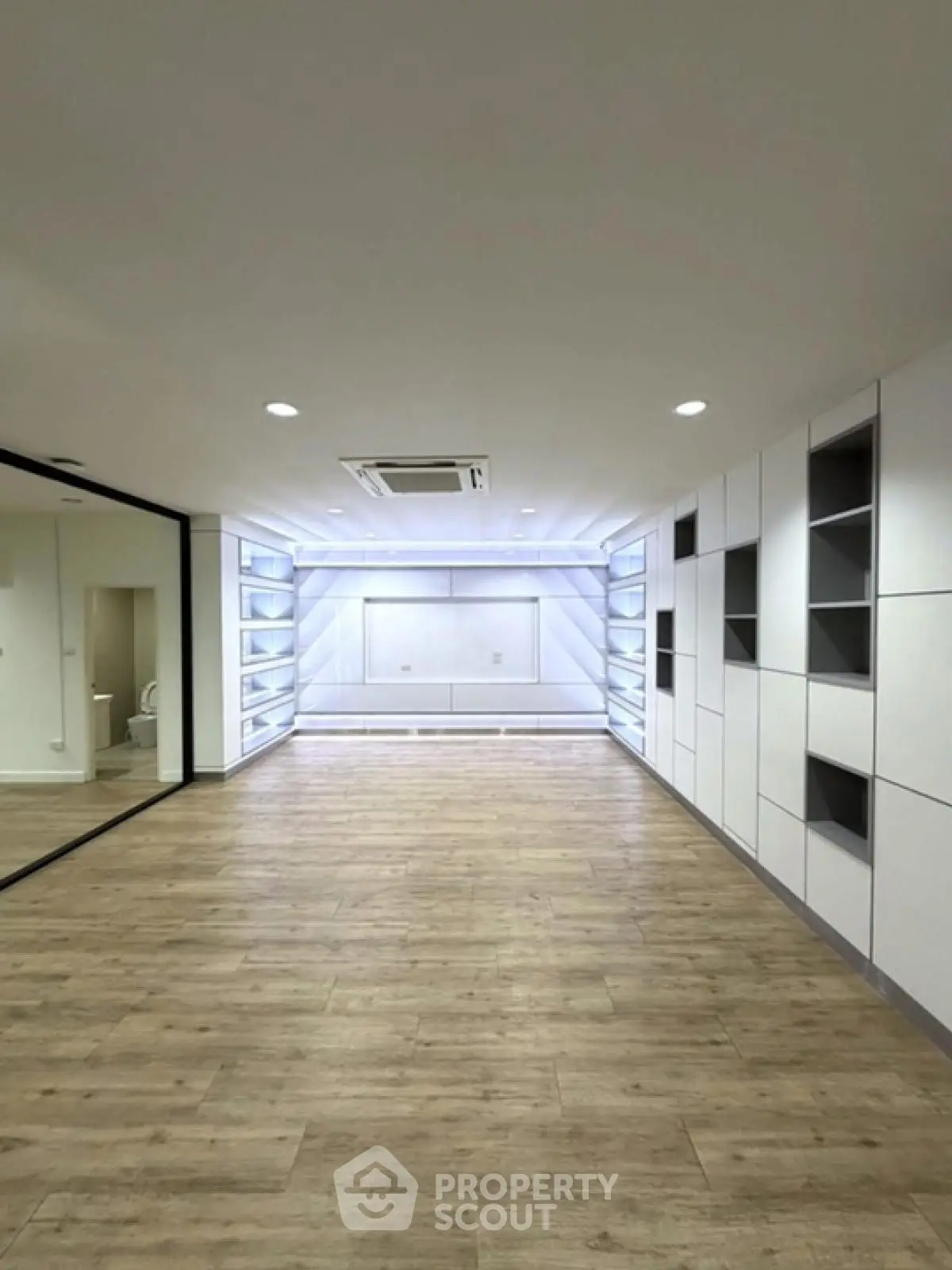 Spacious modern living room with sleek built-in shelves and wooden flooring