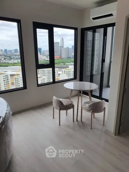 Modern apartment with city view, featuring a cozy dining area and large windows for natural light.