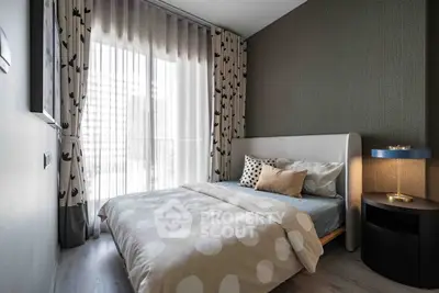 Modern bedroom with stylish decor and large window for natural light.